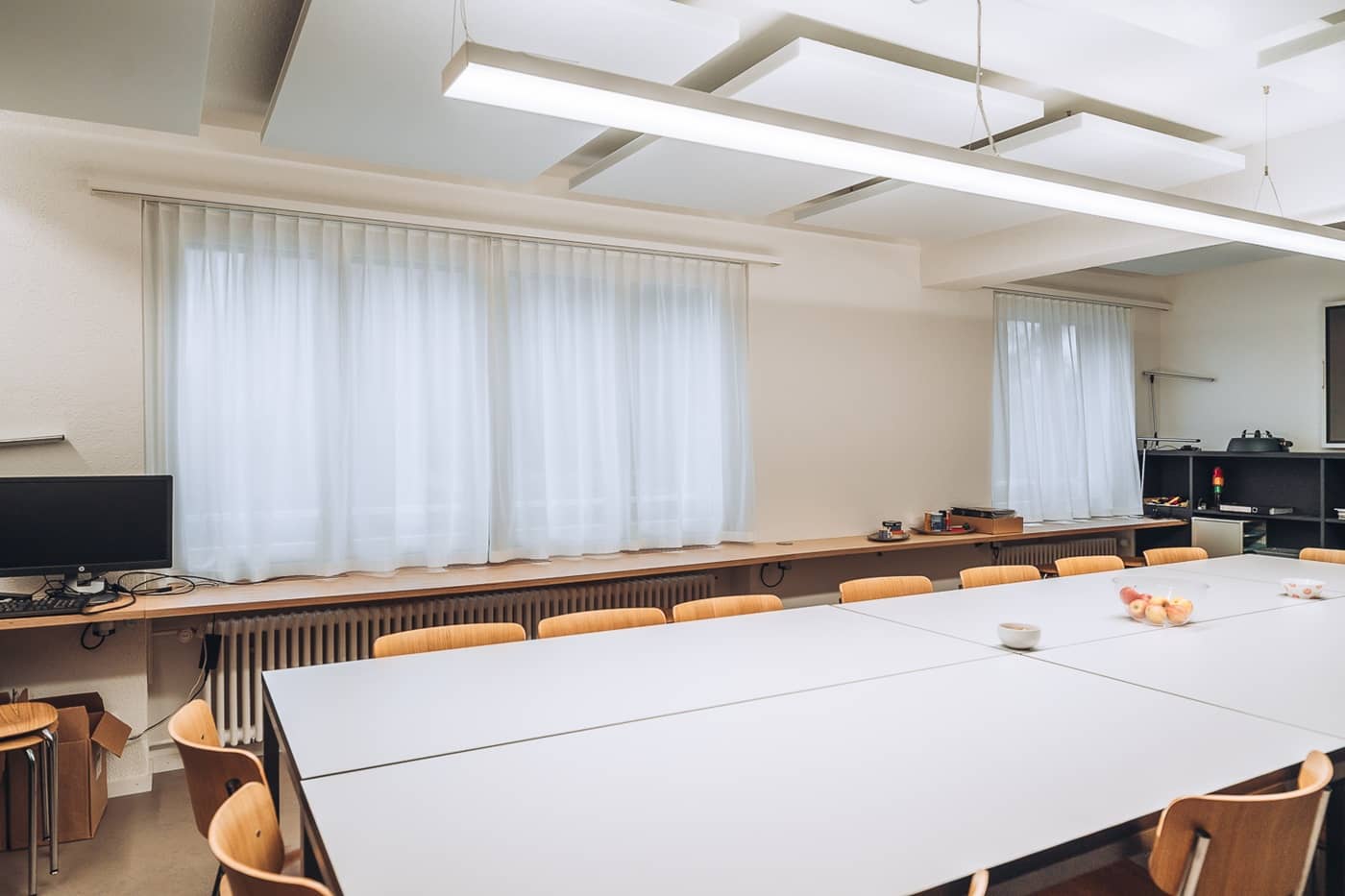 Ein grosser Sitzungsraum mit mehreren Tischen, die einen W&uuml;rfel ergeben und St&uuml;hlen drum herum